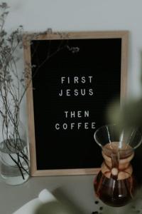 Sign with black background reading : "First Jesus, then coffee"