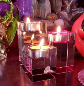 three galss pillars with tea light candles burning on them