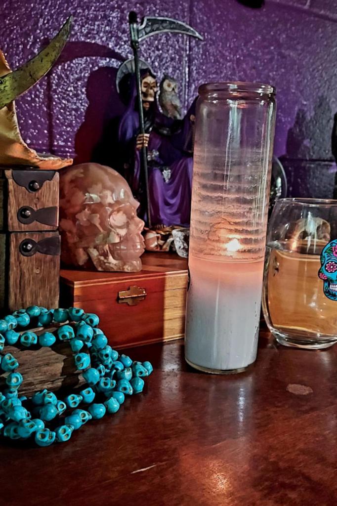 candle burning on an altar with a stone skull