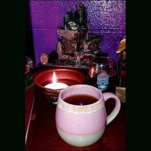 water fountain, candle, and tea on an altar