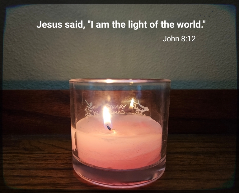 Jesus, the light of the world, promised we won't walk in darkness. Pink candle lit with partial text of John 8:12.