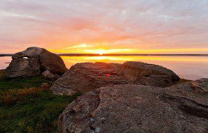 Stones with rising or setting sun and lake
