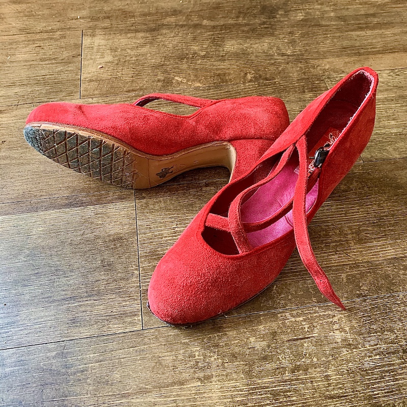 Red suede flamenco shoes on brown studio floor