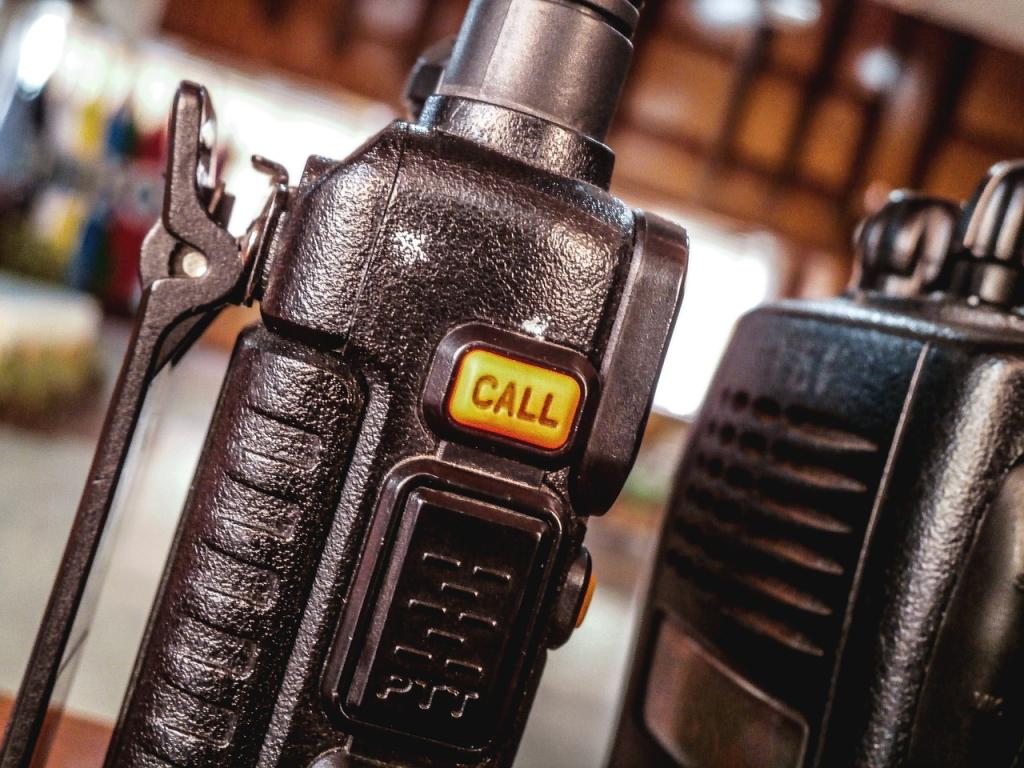Close-up of 2 black walkie talkies, one with a yellow button labeled "call"