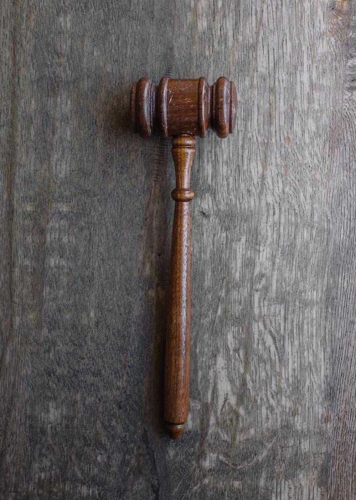 Brown judge's gavel on gray table background
