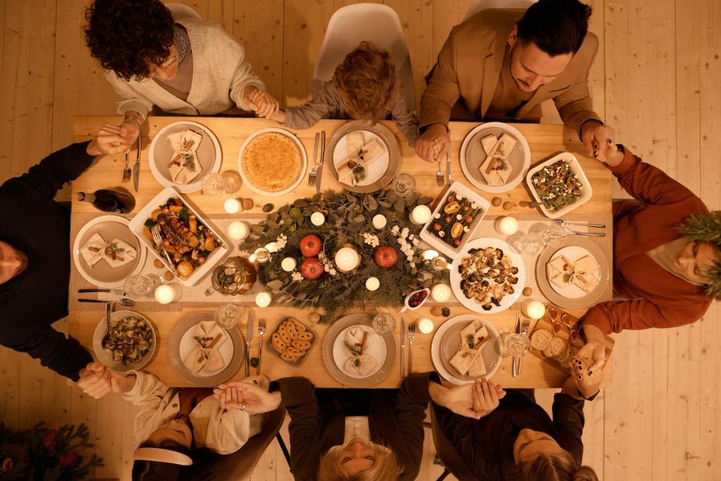 Overhead view of 8 people holding hands in prayer at a Thanksgiving table
