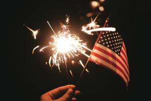 American flag and sparkler against a dark background