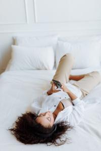 Woman on a bed looking at a cell phone