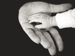 Child with their hand in an adult man's hand