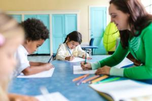 Woman in a green shirt teaching young students