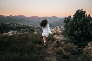 Woman running with her back to the camera in the wilderness