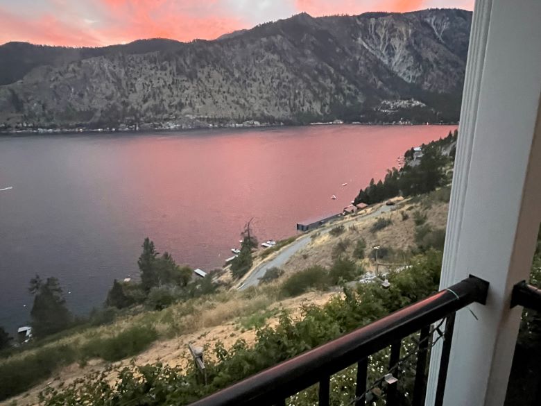 Lake Chelan, Manson, Washington 9 PM with pink orange clouds and their reflection on the lake.