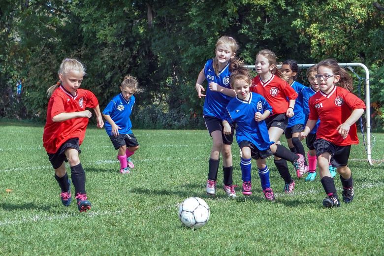 Seven year old girls from two teams follow the soccer ball