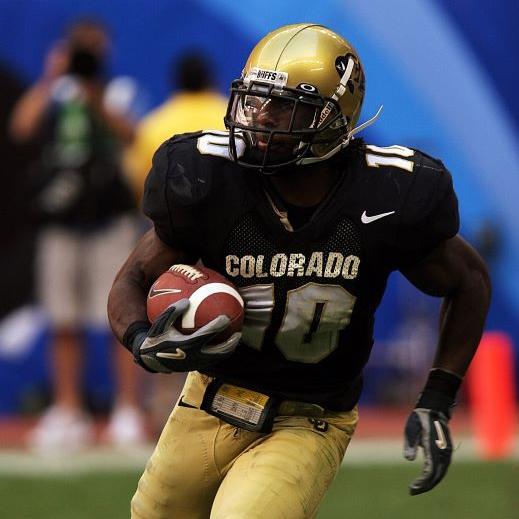 A University of Colorado football player carries the football during a game.