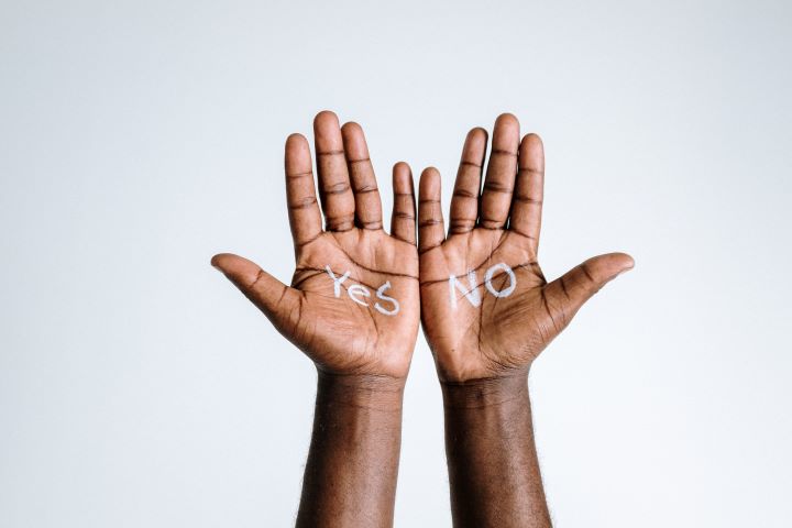 Two hands with palms facing the camera. The left hand reads "Yes" and the right hand reads "No."