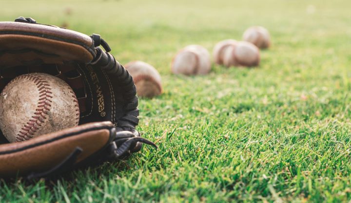 photo of baseball gloves and some worn baseballs