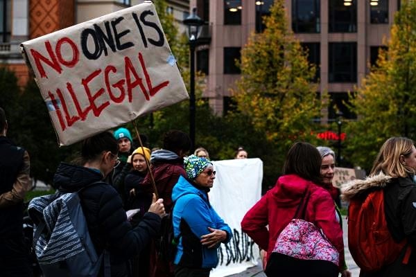 Americans protest the US Immigration policy. One protester's sign reads, "No one is illegal."