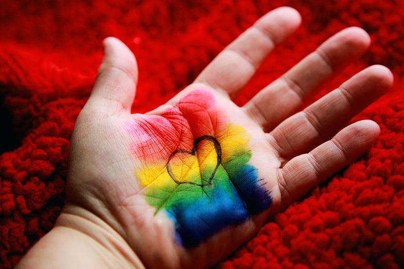 an open hand wth a rainbow heart on the palm