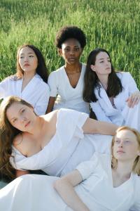 Diverse women in a field in white