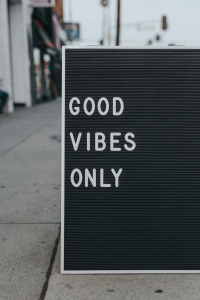 A sidewalk sign reading "Good Vibes Only"