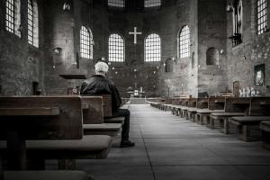 Man sitting alone in an empty church (Black and white photo)