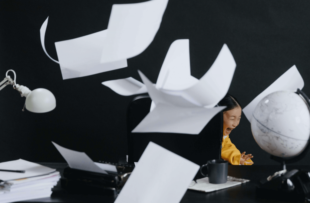 Girl screaming at her desk and throwing up papers