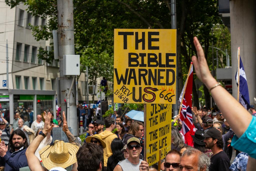 A protest with scriptural signs in the middle of a downtown area.