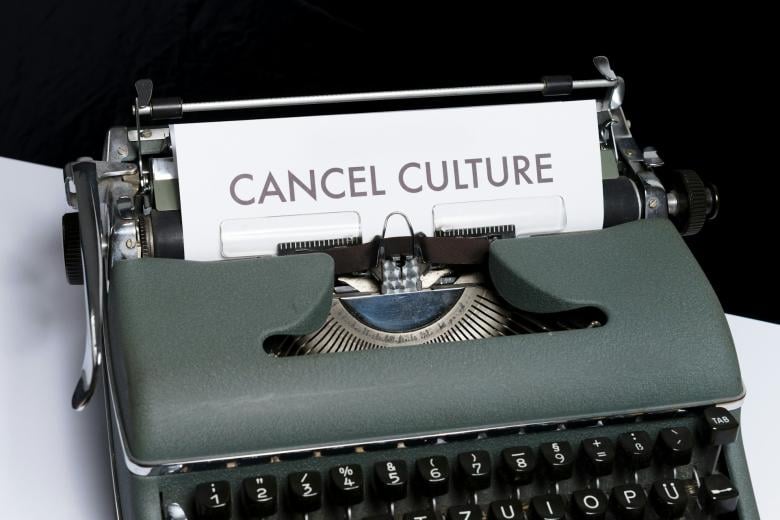 A green typewriter with a written page in the coil titled Cancel Culture.