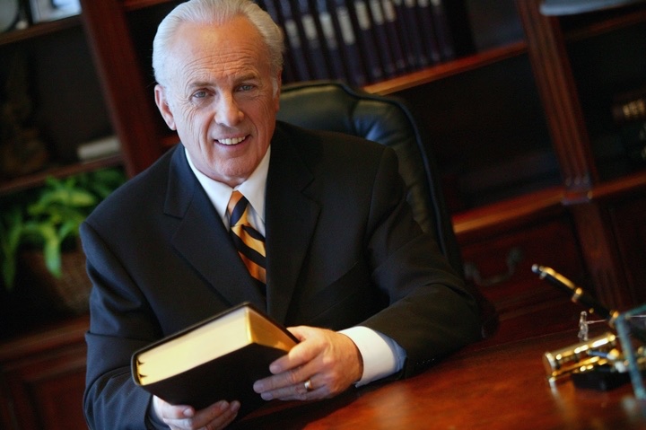 John MacArthur holding the acclaimed study bible that bears his name 