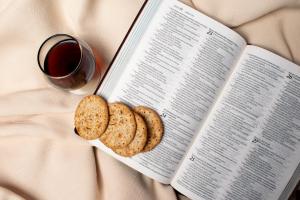 An image of crackers, grape juice and the Bible