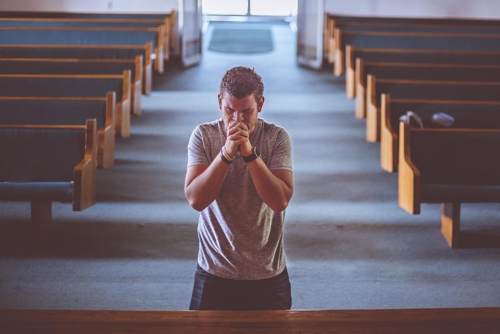 A man kneeling in church praying at the altar.