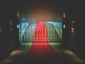 A wide walkway with a red carpet leading up to a barricaded entry.