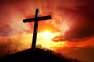 A silhouette of the Cross on a hill in the sunset