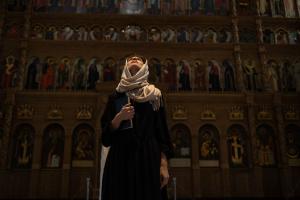 A woman dressed in historic Biblical garb standing in an Orthodox church. 