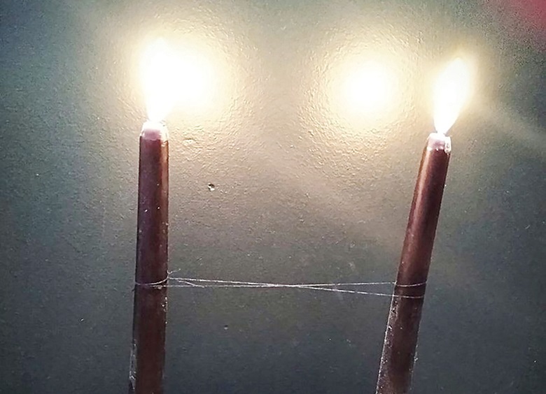 Cord cutting black candles wrapped by black thread
