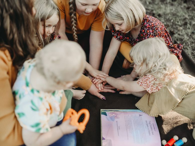 Mom playing and reading Bible with daughters.