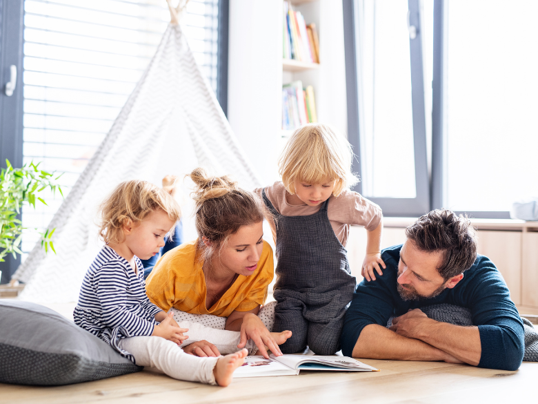 family reading a book together in a play tent