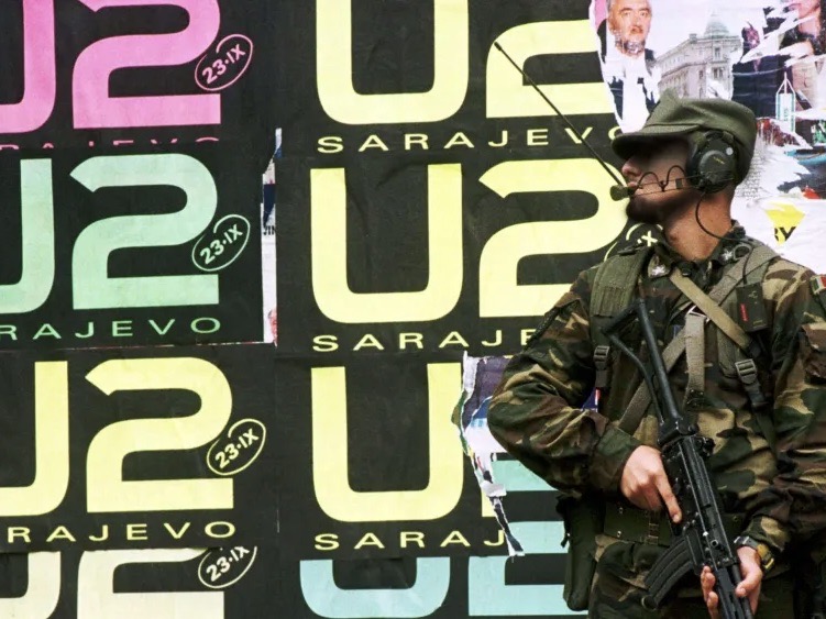 An armed guard stands alert to protect concertgoers at a U2 Concert in Sarajevo, September 23, 1997. 