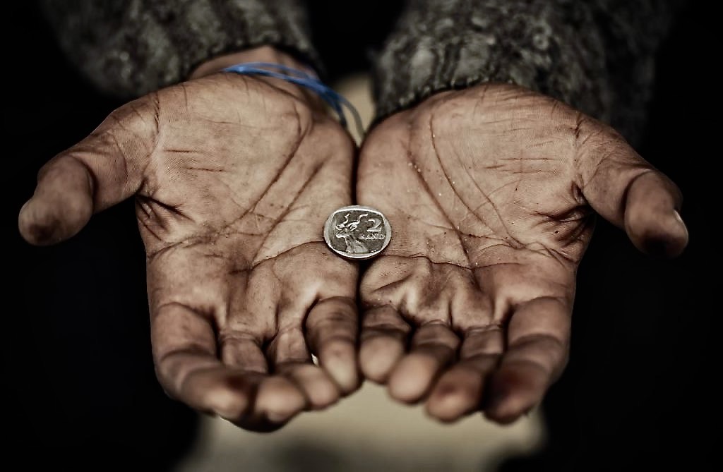 Dirty hands holding coin.