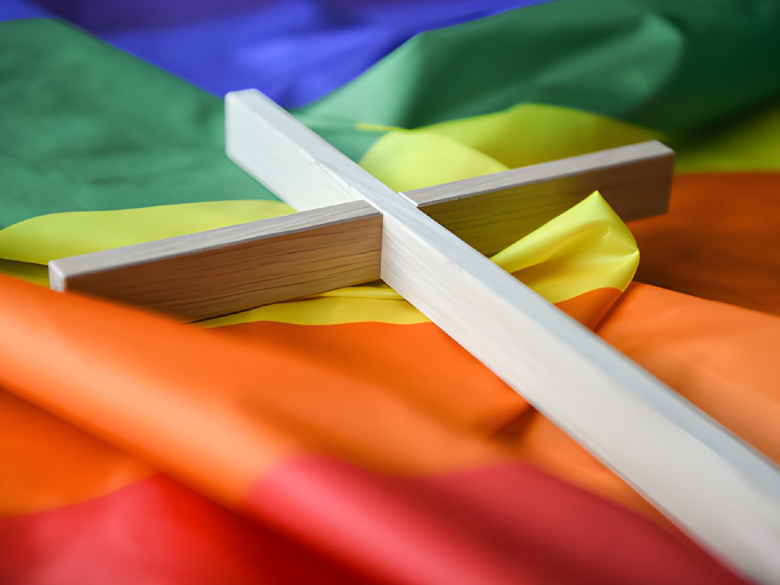 A wooden cross lies on a rainbow flag in Bonn, Germany, March 16, 2021. 
