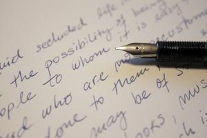 Tip of a fountain pen resting on handwritten letter