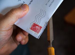 Hand holds envelope received in mail