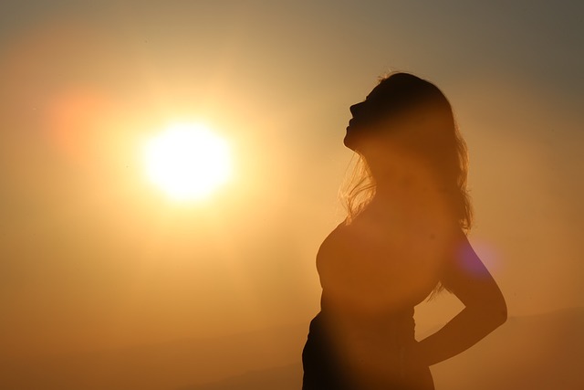 Woman standing sideways in the shadows of a shining sun