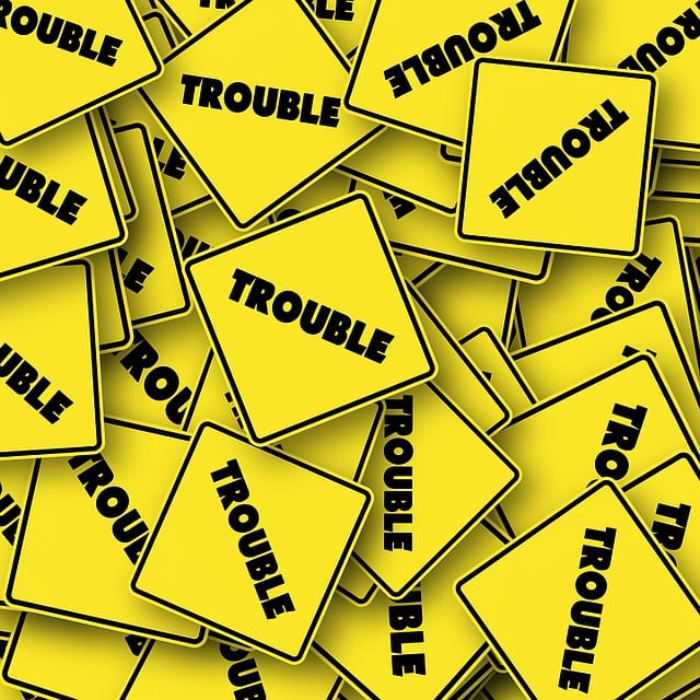 Numerous small yellow traffic signs saying "TROUBLE" 