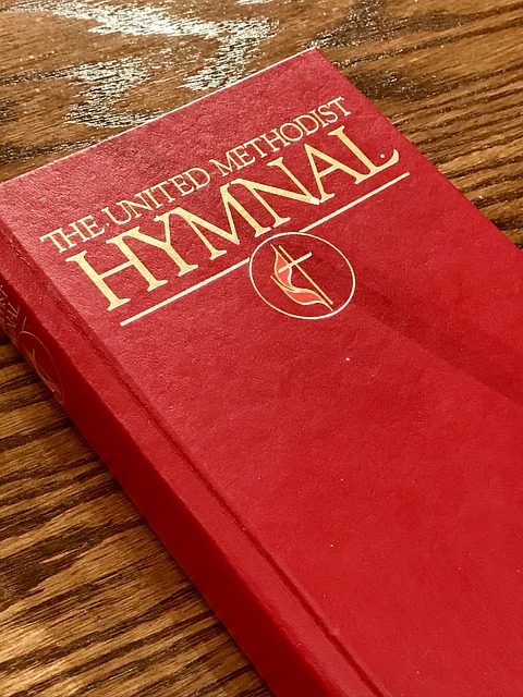 Red United Methodist Hymnal lying on a wooden table
