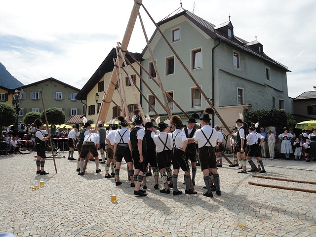 Men in traditional costume raising a Maypole in a European village