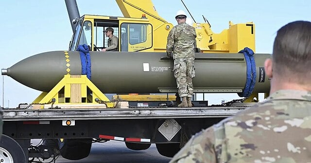 Picture of military bomb loaded on truck with three military individuals around it
