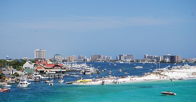 View from the distance across the blue=green water to Destin, Florida with many boats in the water