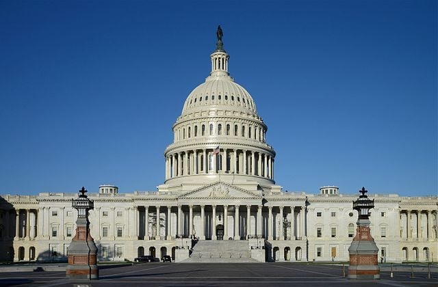 Front view of the US Capitol Building against a cloudless blue sky