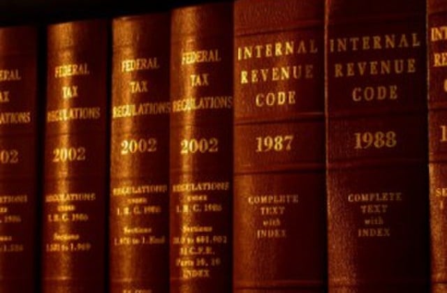 View of dark red books with gold lettering identifying them as Internal Revenue Code, lined up on a shelf 